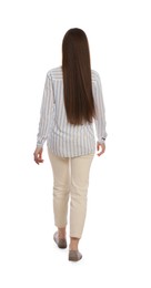 Young woman in casual outfit walking on white background, back view