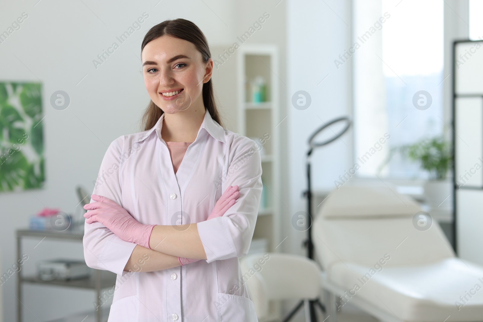 Photo of Cosmetologist in medical uniform in clinic, space for text