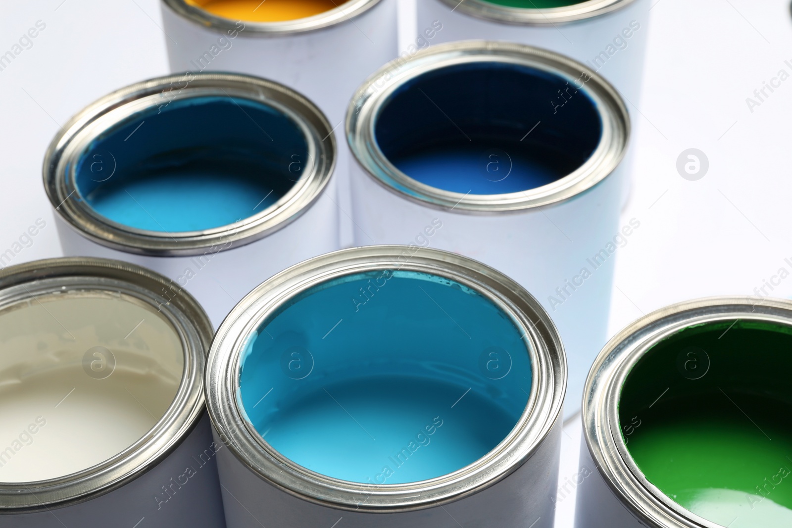 Photo of Open paint cans on white background, closeup