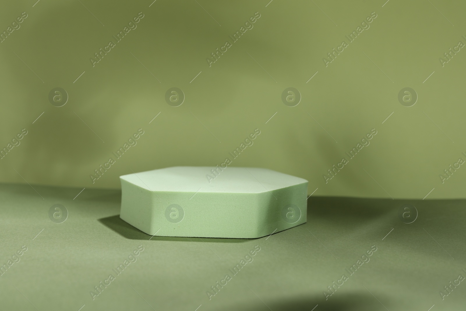 Photo of Presentation of product. Podium and shadows on light green background. Space for text