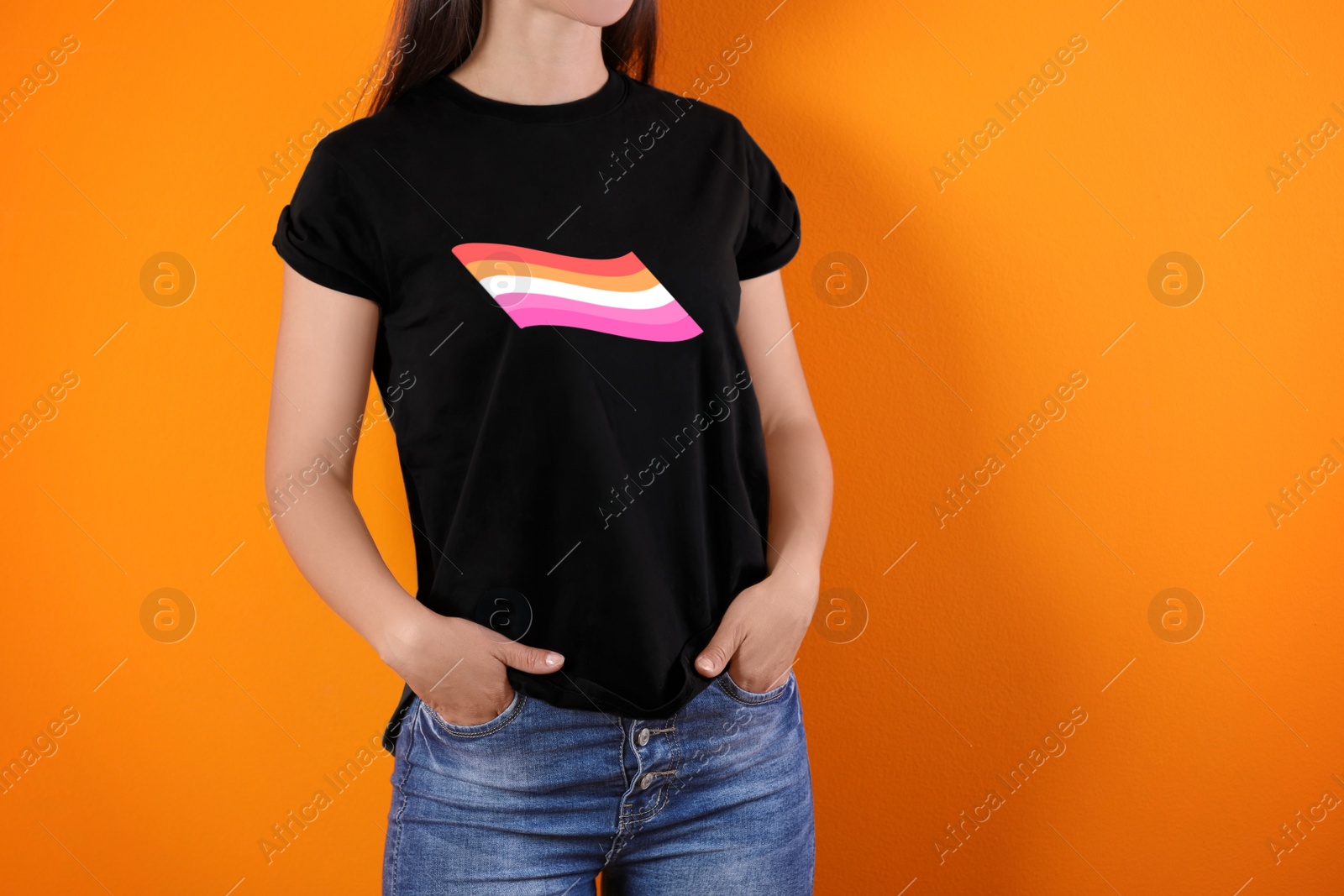 Image of Young woman wearing black t-shirt with lesbian flag on orange background. LGBT concept