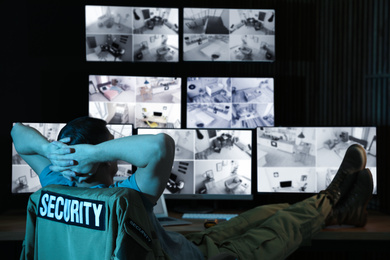 Photo of Security guard monitoring modern CCTV cameras at night