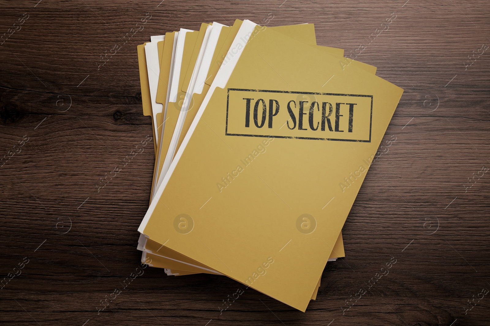 Image of Yellow file with documents and Top Secret stamp on wooden table, top view