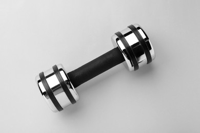 Photo of Metal dumbbell on light background, top view
