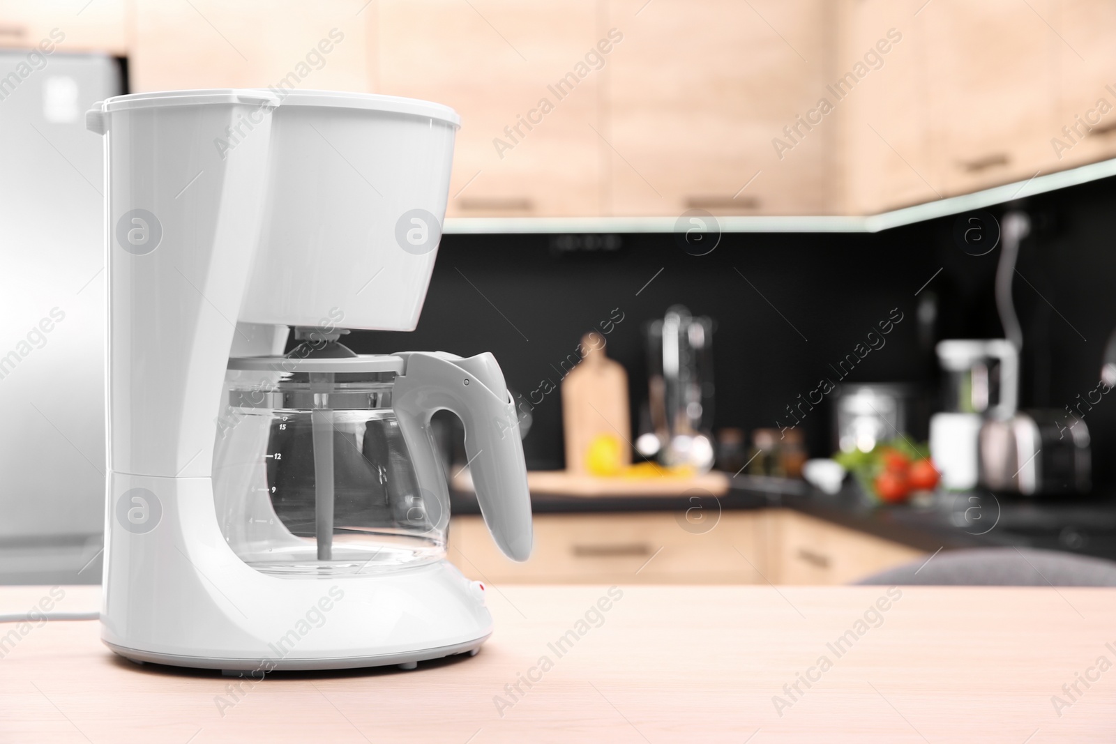 Photo of Modern coffee maker on wooden table in kitchen. Space for text