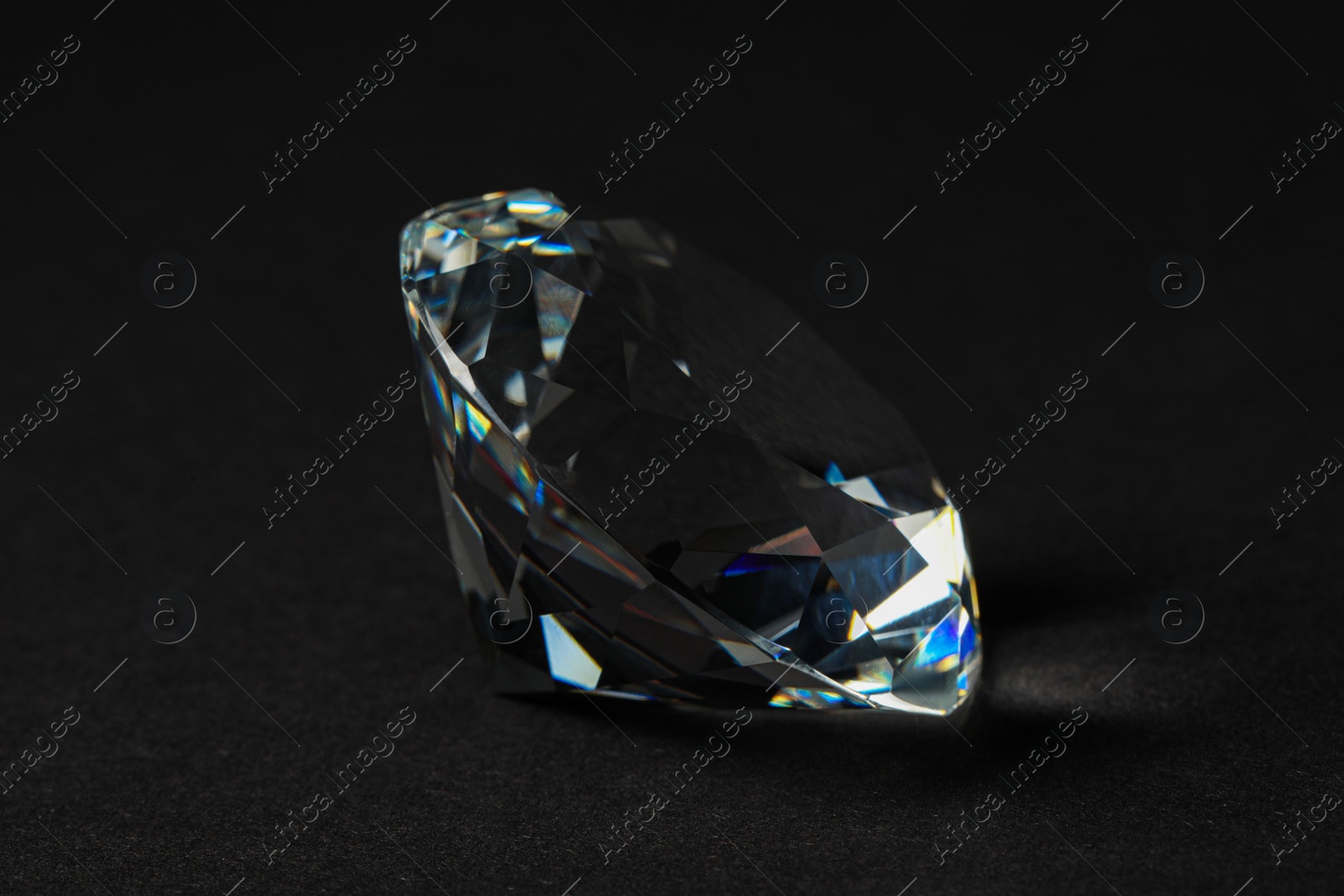 Photo of Beautiful dazzling diamond on dark background, closeup. Precious gemstone