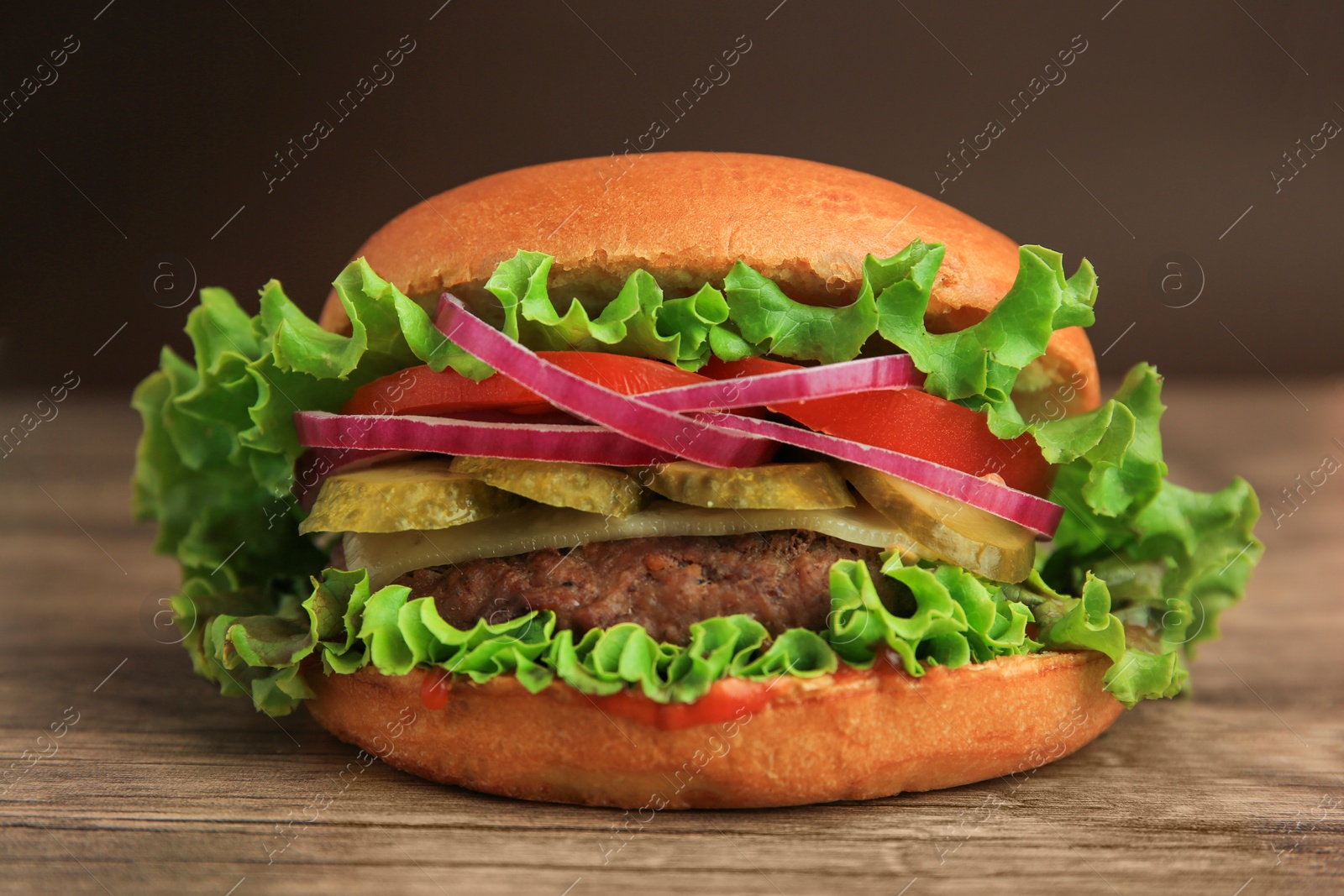 Photo of One tasty burger on wooden table, closeup