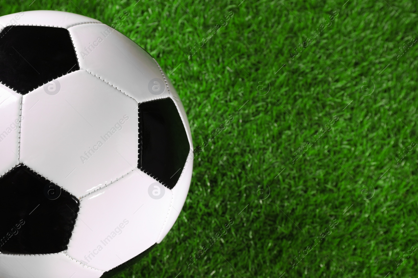 Photo of One soccer ball on green grass, space for text. Sports equipment