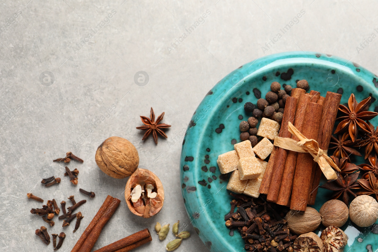 Photo of Different aromatic spices on light textured table, flat lay. Space for text