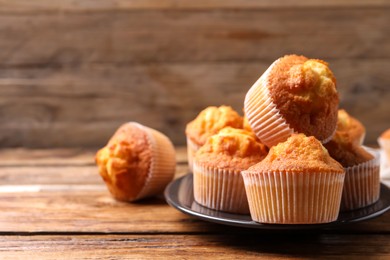 Delicious sweet muffins on wooden table, closeup. Space for text