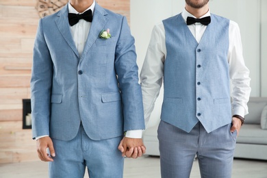 Photo of Newlywed gay couple holding hands at home