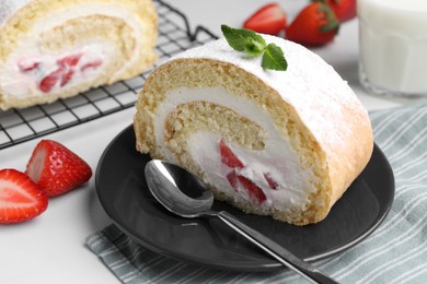 Photo of Slice of delicious sponge cake roll with strawberries and cream served on white table, closeup