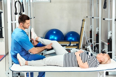 Photo of Physiotherapist working with patient in rehabilitation center