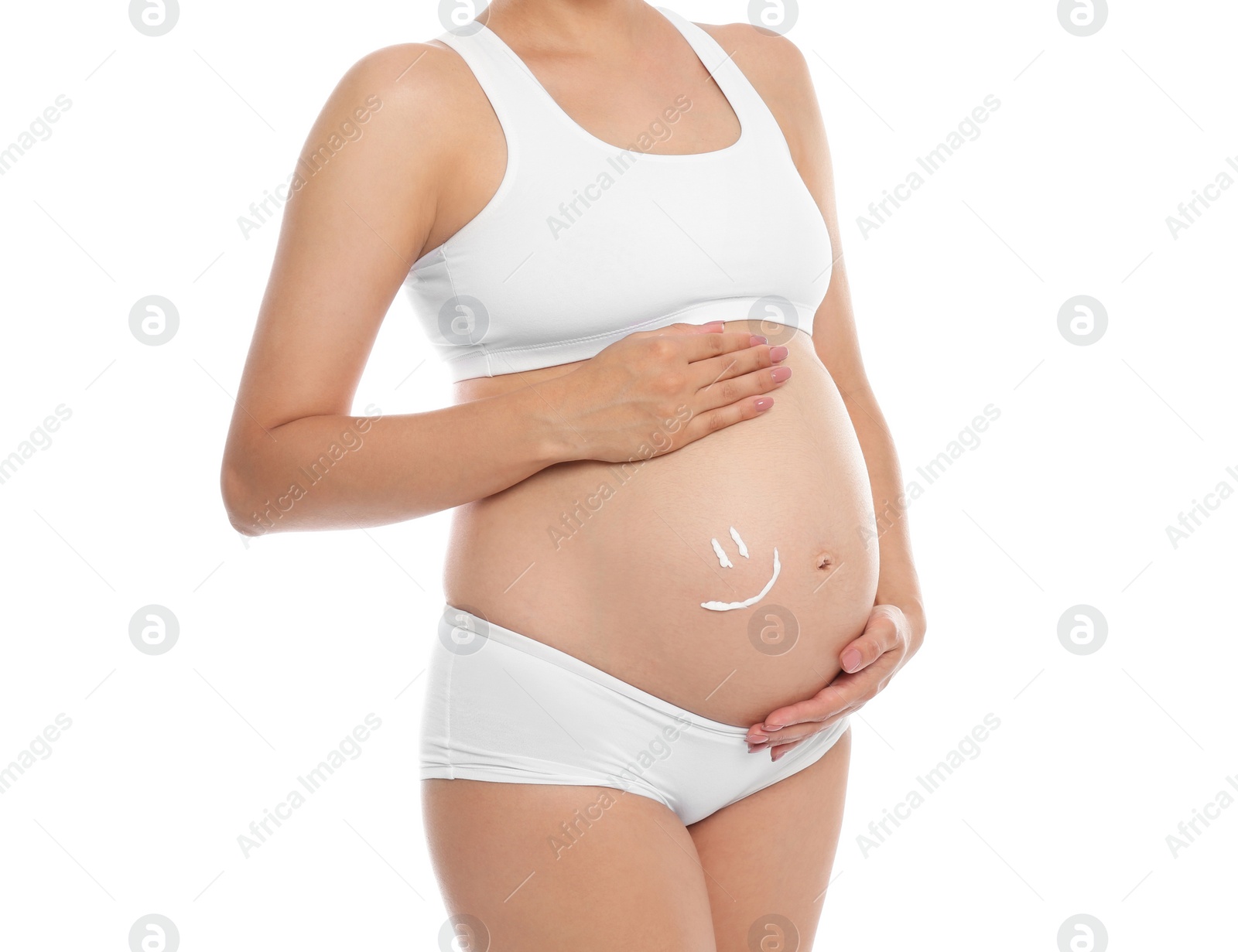 Photo of Smile painted with body cream on pregnant woman's belly against white background, closeup