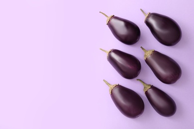 Photo of Raw ripe eggplants on light background, flat lay. Space for text