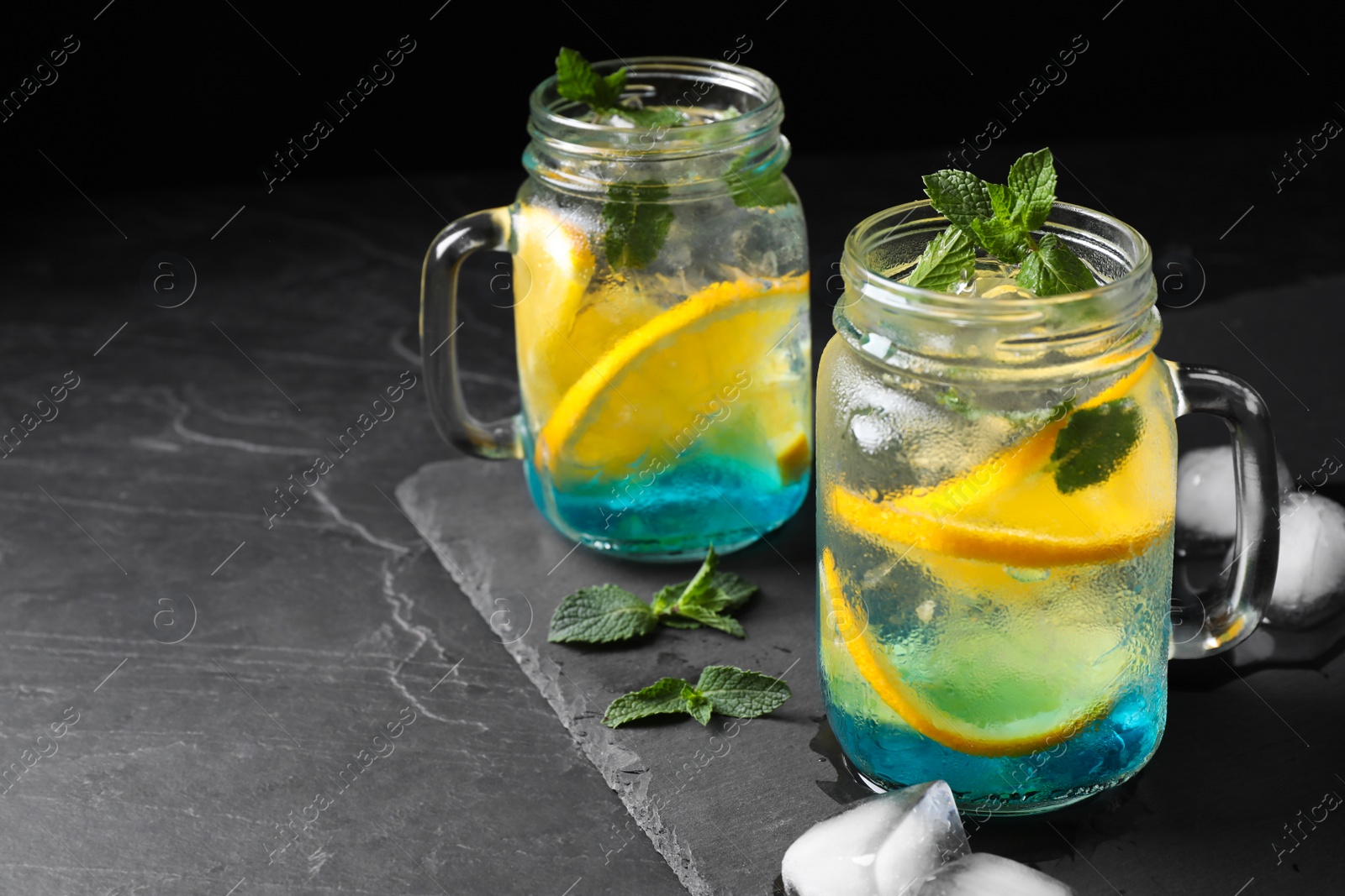 Photo of Delicious refreshing drink on black table. Space for text