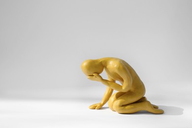 Photo of Plasticine figure of crying human on white background. Space for text