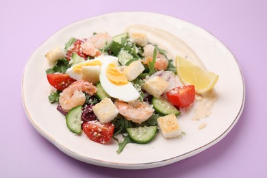 Photo of Delicious Caesar salad with shrimps on violet background, closeup