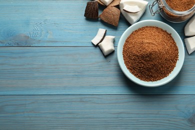 Flat lay composition with natural coconut sugar on blue wooden table, space for text