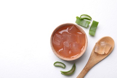 Photo of Aloe vera gel and slices of plant on white background, flat lay. Space for text
