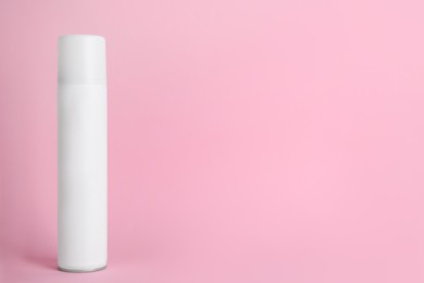 Photo of Bottle of dry shampoo on pink background, space for text
