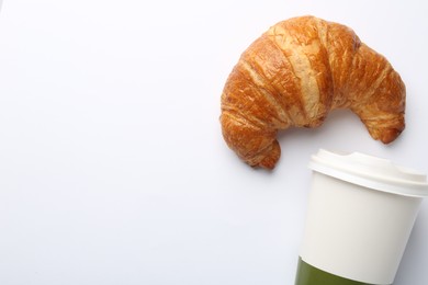 Delicious fresh croissant and paper cup with coffee on white background, flat lay. Space for text