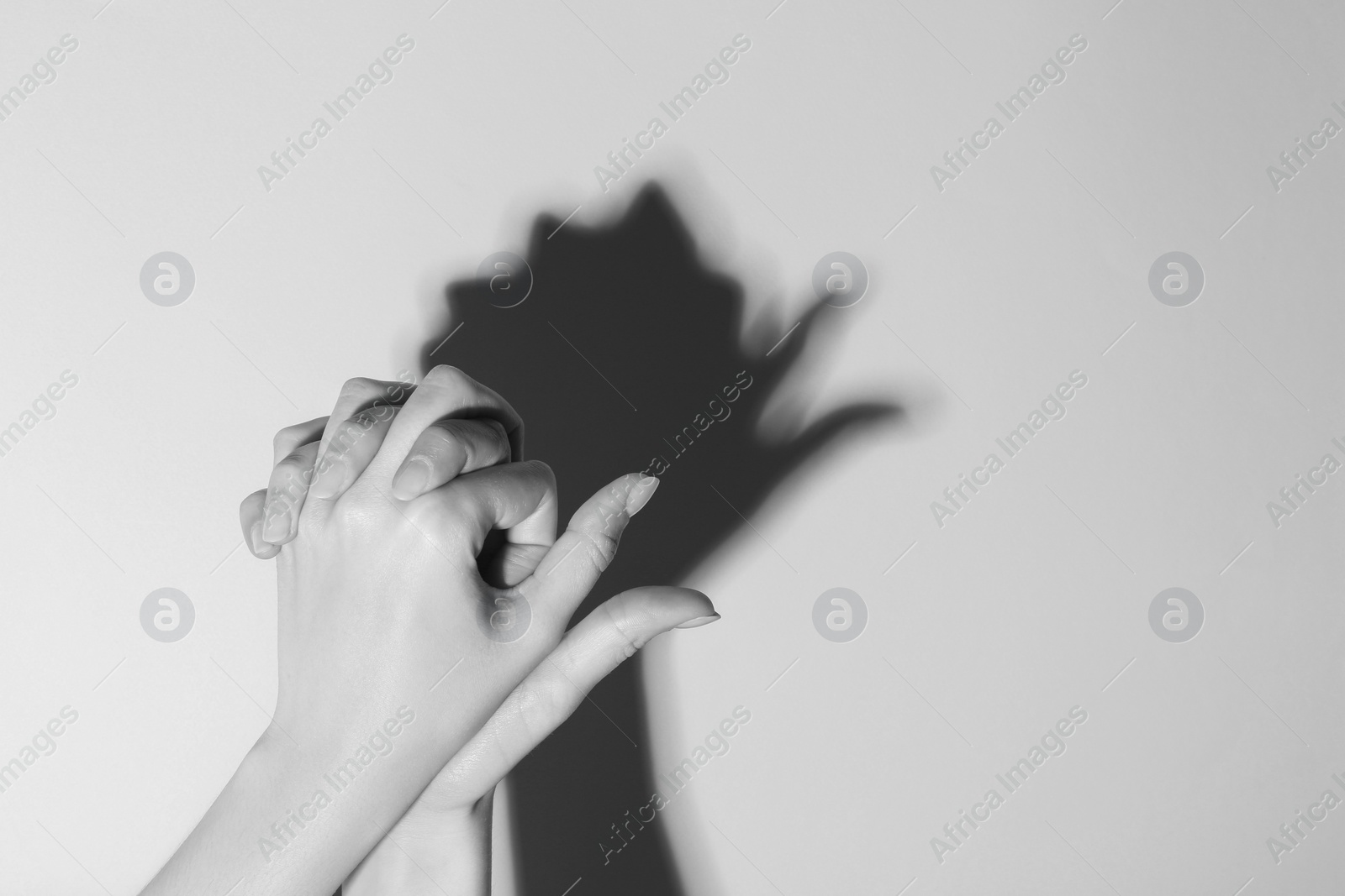 Photo of Woman making hand gesture like bird on light background, closeup with space for text. Black and white effect