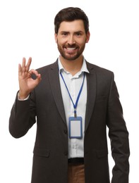 Smiling man with VIP pass badge showing OK gesture on white background