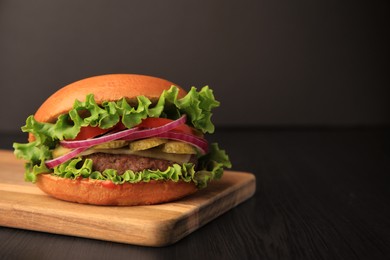 One tasty burger on wooden table. Space for text
