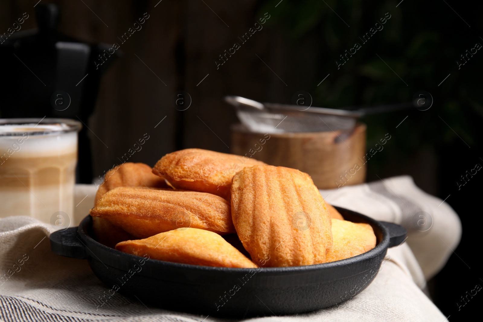 Photo of Delicious madeleine cakes in frying pan on table