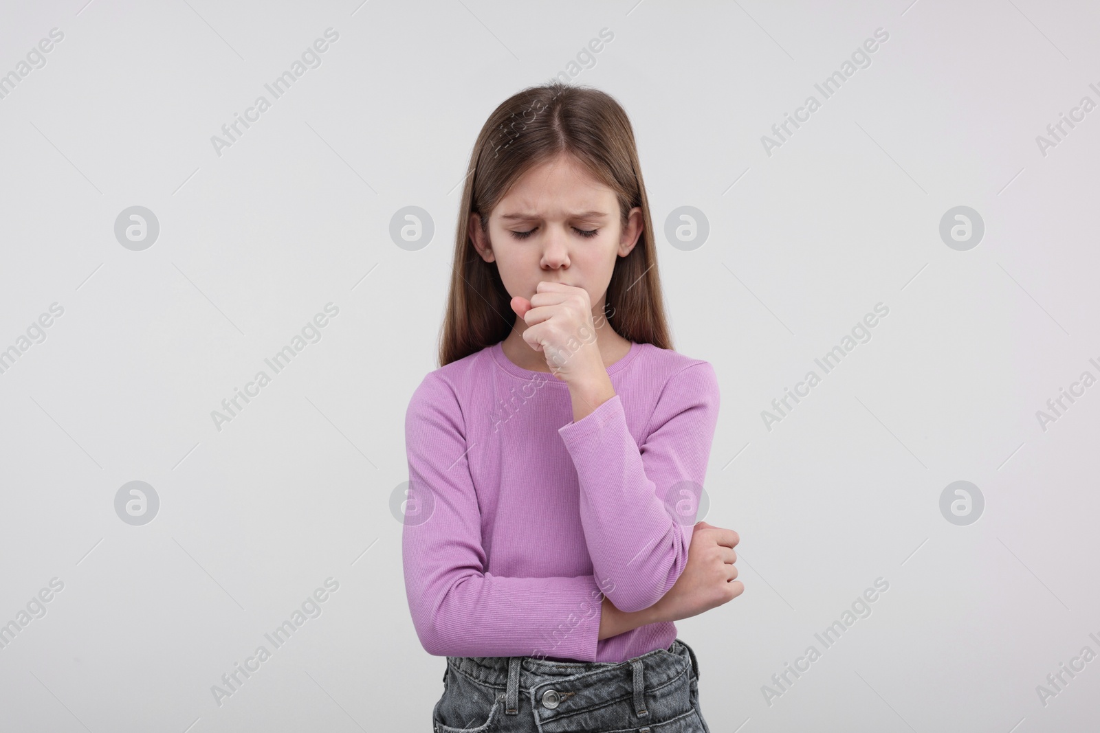 Photo of Sick girl coughing on light background. Cold symptoms