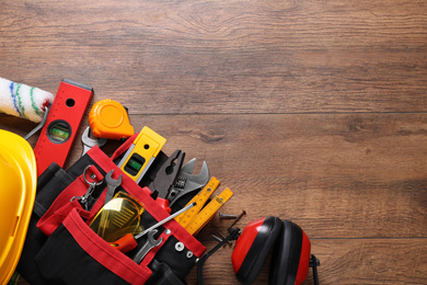 Photo of Flat lay composition with different construction tools and space for text on wooden background