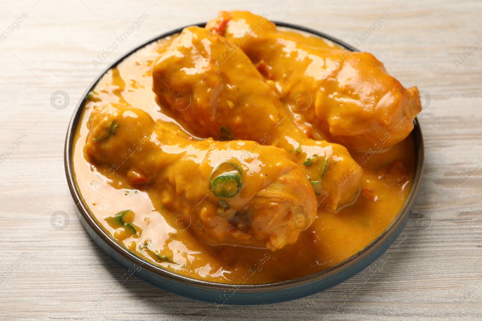 Photo of Tasty chicken curry on wooden table, closeup