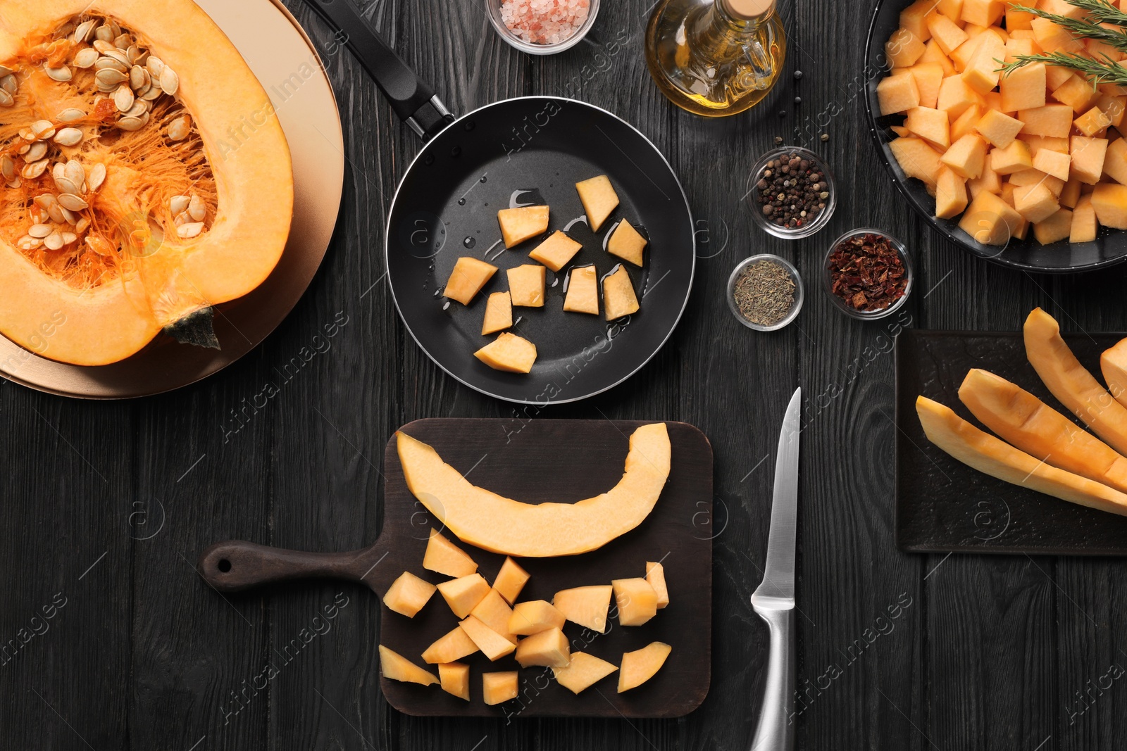 Photo of Flat lay composition with cut fresh ripe pumpkin on black wooden table