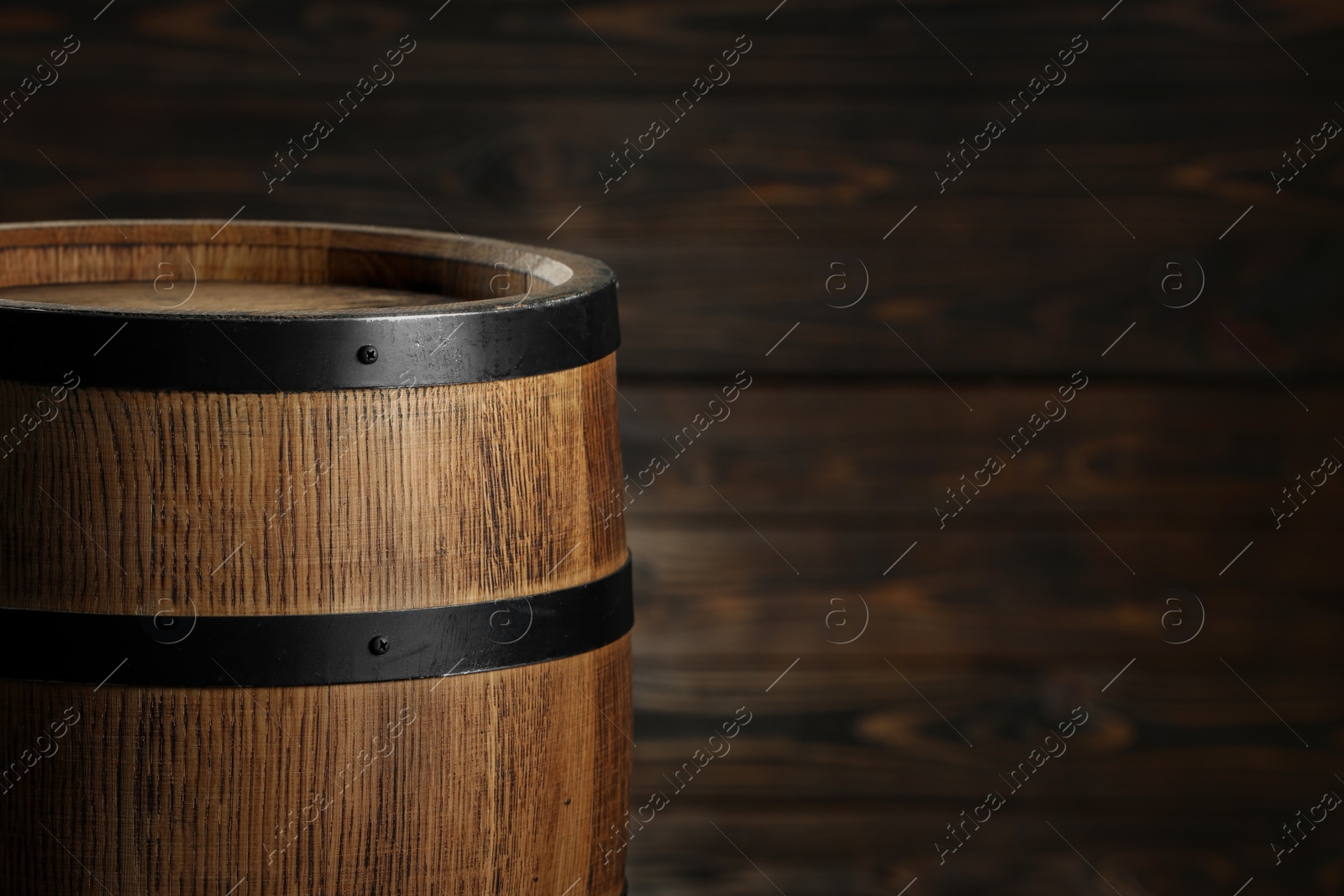 Photo of One wooden barrel near wall, closeup. Space for text