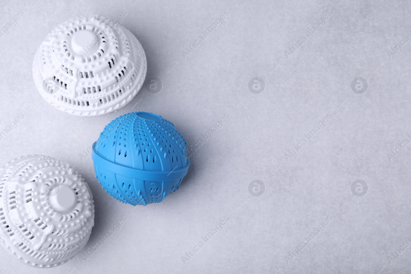 Photo of Laundry dryer balls on light grey table, flat lay. Space for text