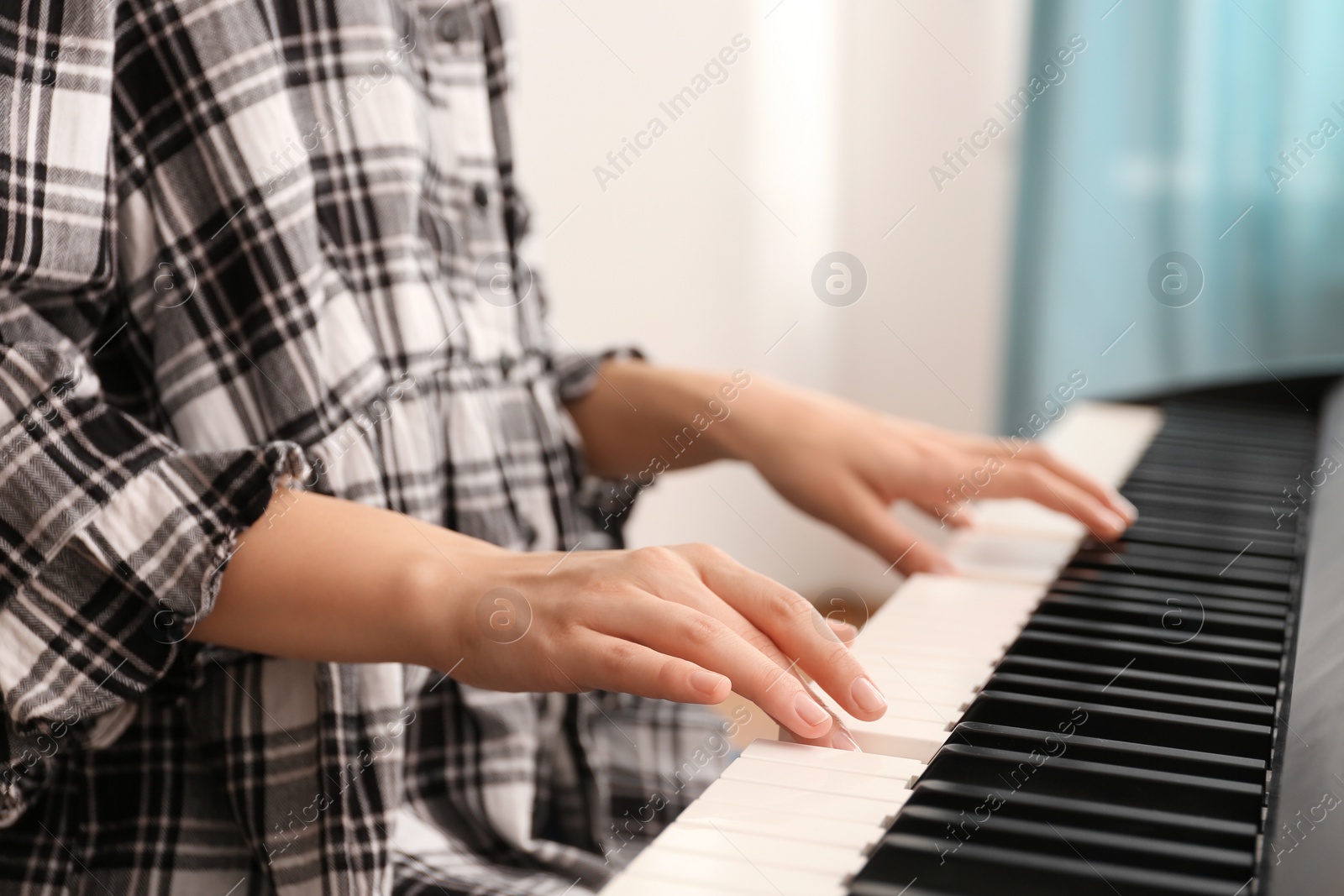 Photo of Young woman playing piano at home, closeup