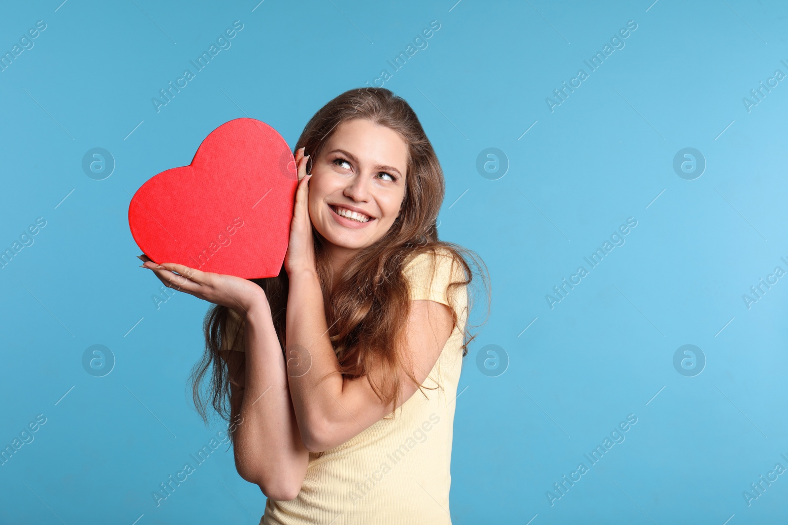 Photo of Portrait of young woman with decorative heart on color background. Space for text