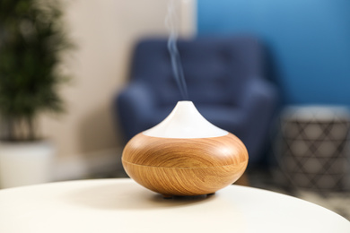 Aroma oil diffuser on white table at home. Air freshener