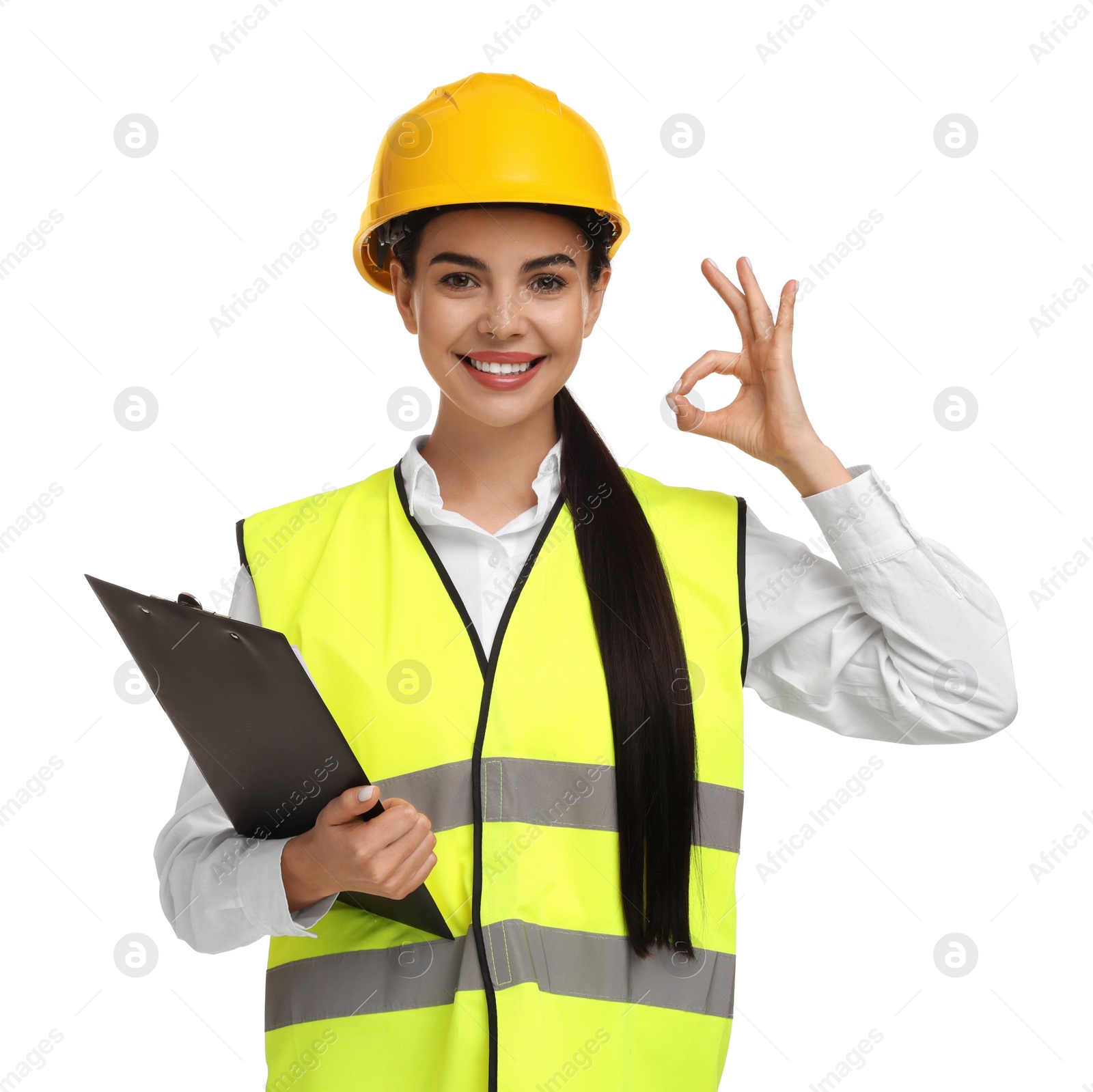 Photo of Engineer in hard hat holding clipboard and showing ok gesture on white background