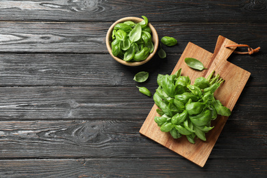 Photo of Fresh green basil on black wooden table, flat lay. Space for text