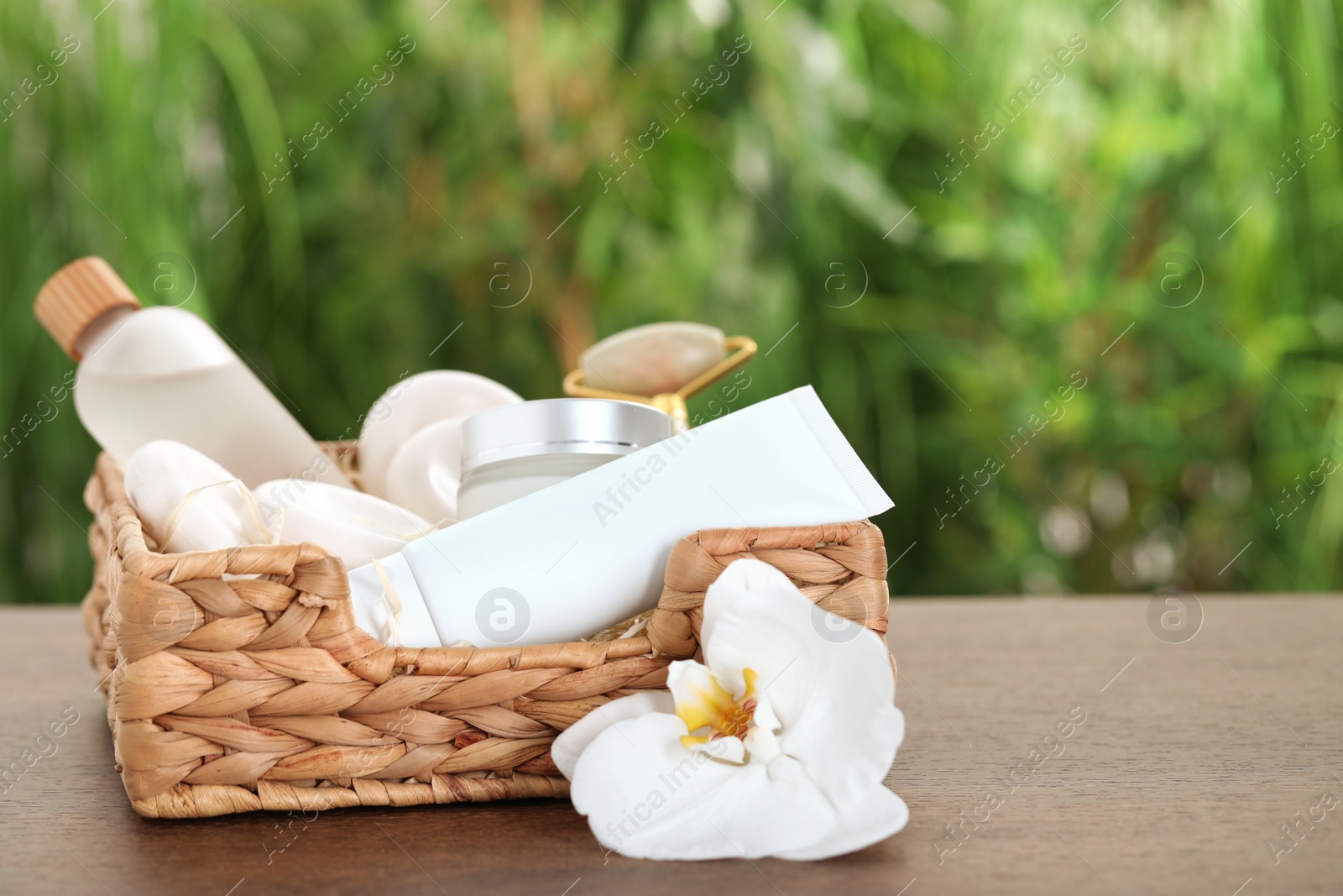 Photo of Spa gift set with different products on wooden table against blurred background