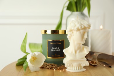 Beautiful David bust candle on wooden table. Stylish decor