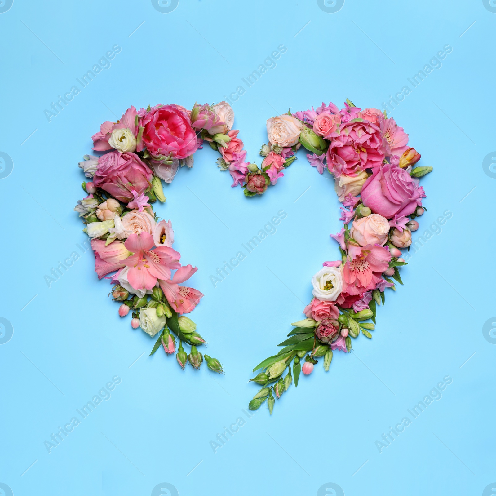 Photo of Beautiful heart shaped floral composition on turquoise background, flat lay