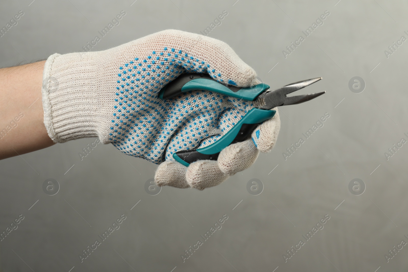 Photo of Man with bent nose pliers on grey background, closeup