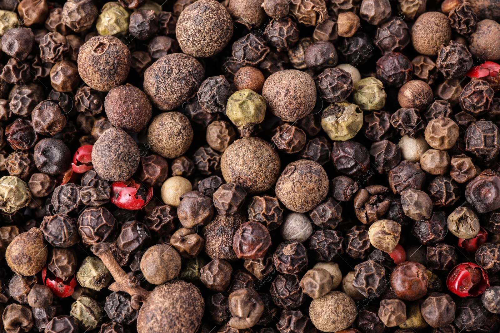 Photo of Pepper grains mix as background, top view