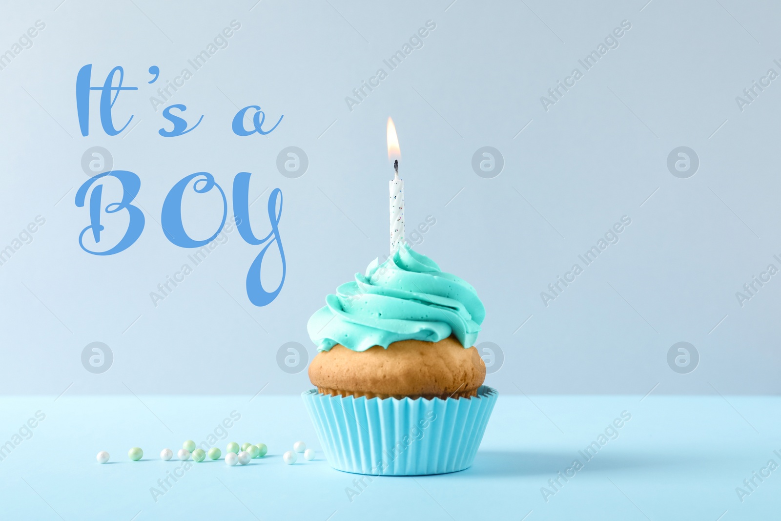 Image of Baby shower cupcake with candle for boy on light blue table