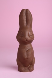 Photo of Chocolate bunny on pink background. Easter celebration