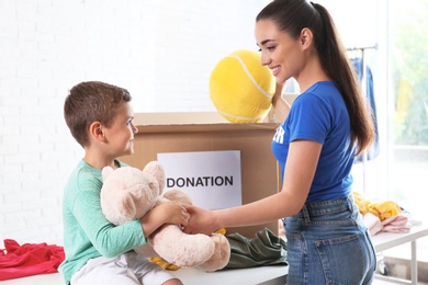 Photo of Volunteer with child sorting donation goods indoors
