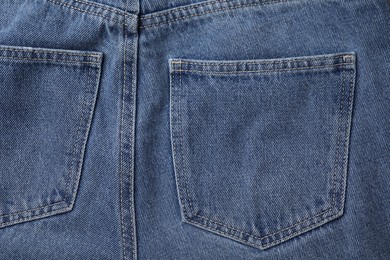 Jeans with pockets as background, top view